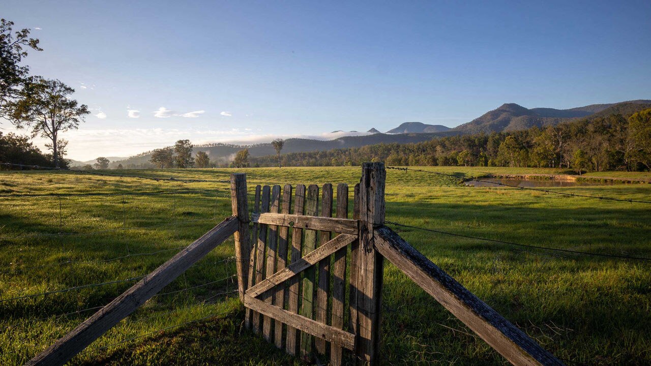 A picture of a wooden fence against a green field